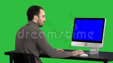 商人在绿色屏幕上使用电脑，Chroma键。 蓝色屏幕模拟显示。